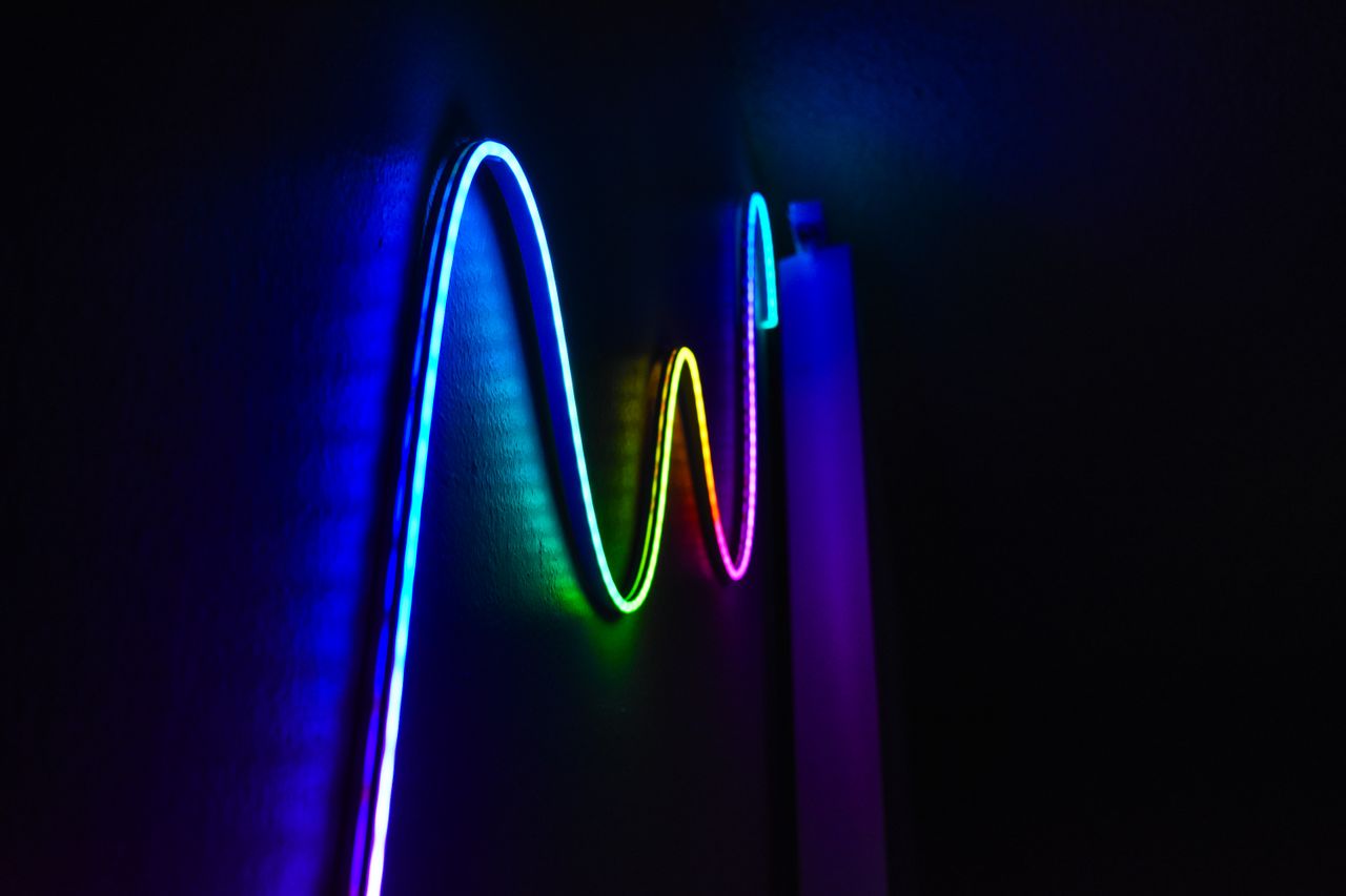 Crafting Captivating Headlines: Your awesome post title goes here Colorful neon wave pattern LED lights illuminating a dark room for a modern home decor aesthetic.